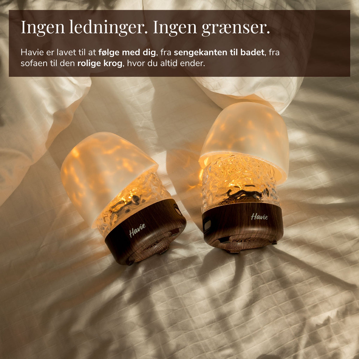 To ledningsfri, genopladelige Havie-lamper lyser varmt på en seng.