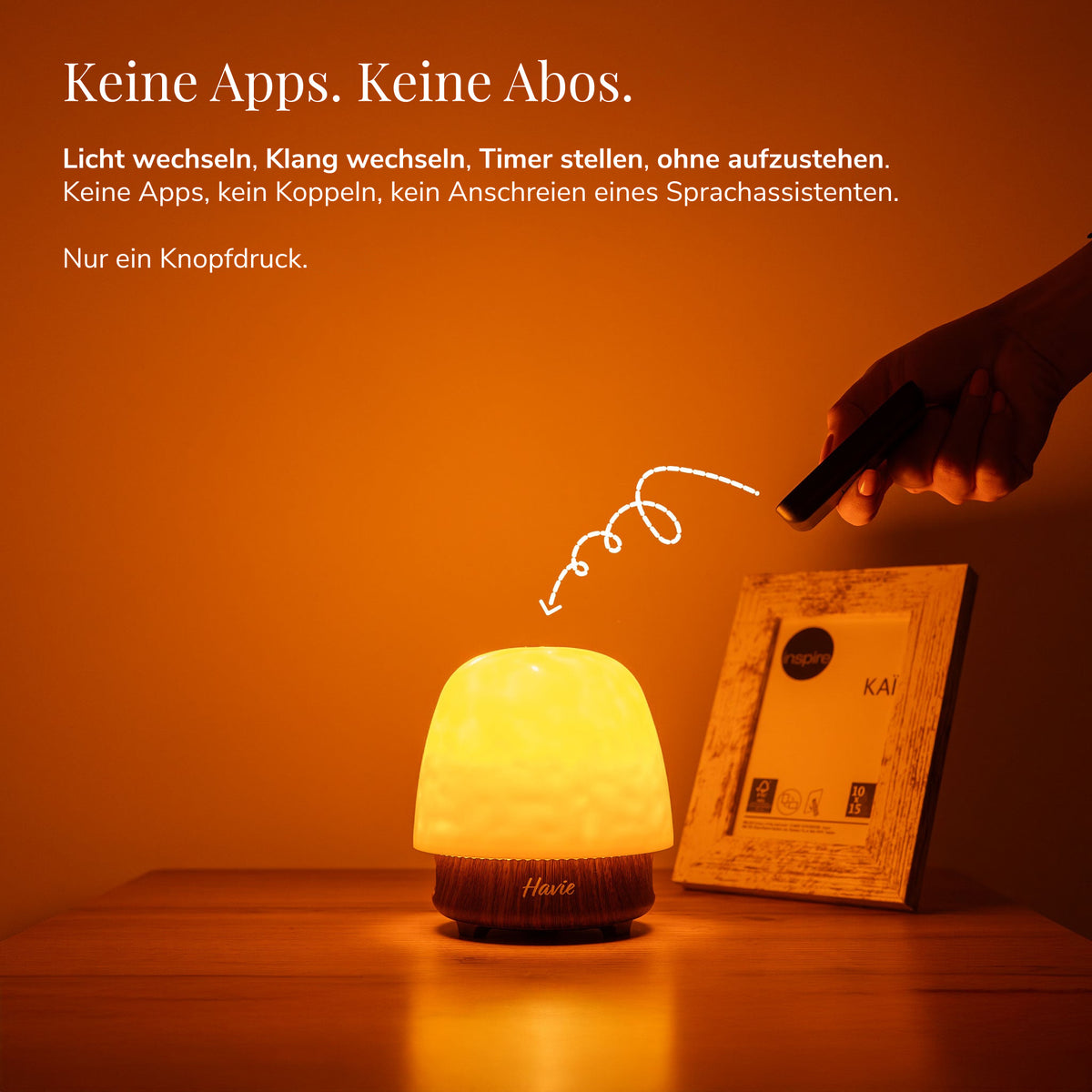 Havie wird per Fernbedienung gesteuert und leuchtet warm orange auf einem Nachttisch.