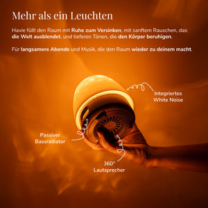 Havie mit integriertem White Noise und 360-Grad-Lautsprecher verbreitet einen warmen orangefarbenen Schein.